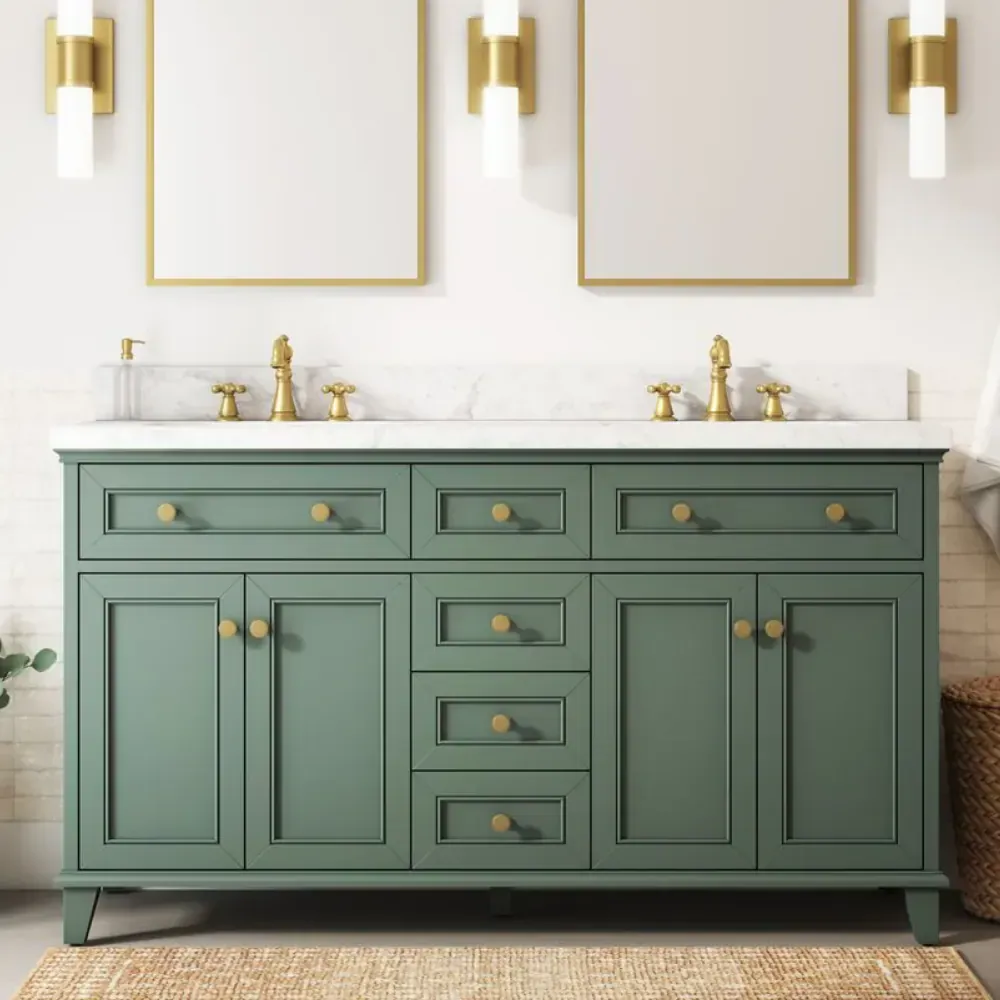 Sage green double sink bathroom vanity with a white marble top, brass cross-handle faucets and two gold-framed mirrors