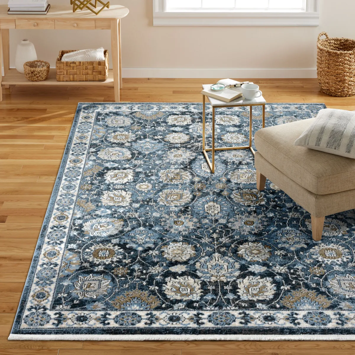 Navy blue Persian-style area rug with a cream and gold floral medallion pattern and fringed edge on a light wood floor